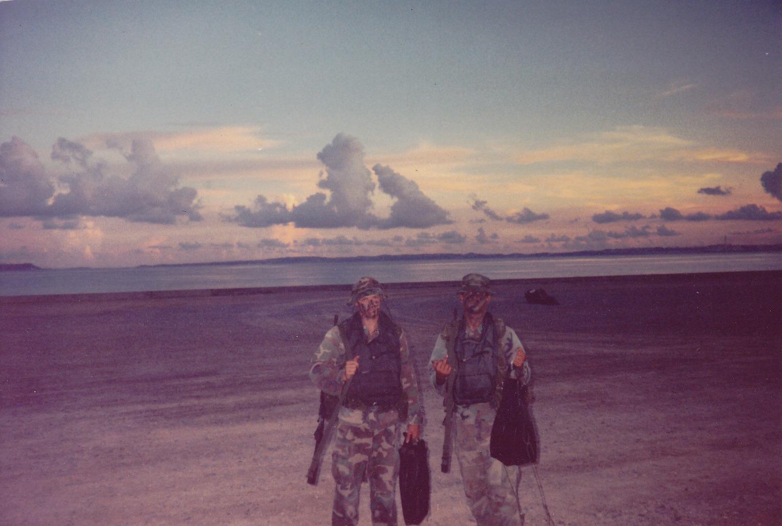 John Fite, left, and his swim buddy Rocco DiPofi standing in camouflage and equipment on Kin Blue Beach, Okinawa, at sunset in 1995 before a nighttime Zodiac mission during Scout Swimmer School.